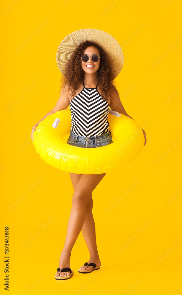 Sticker beautiful young african-american woman with inflatable ring on color background