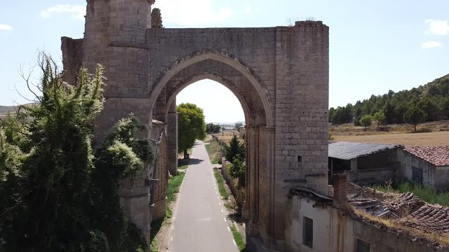 Aerial flying through archway of ruins of San Antón Monastery in Castrojeriz