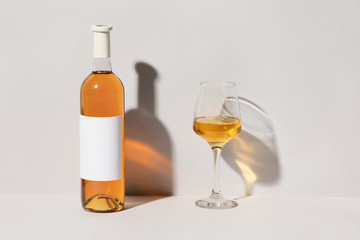 Bottle and glass of wine on light background