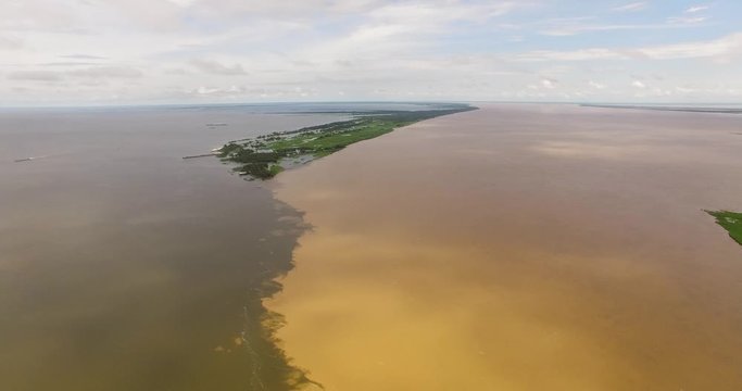 Meeting of the waters of the Amazon River and the Tapajos River. The waters of the Amazon River are brown in color and the Tapajos River is black.
