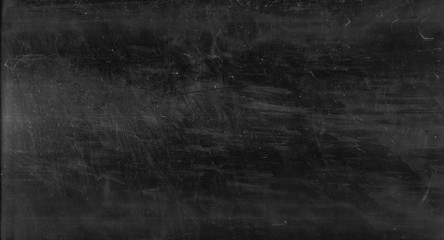 Obraz na płótnie Canvas Distressed abstract background. Scratched texture. Dirty black chalkboard with white dust stains.