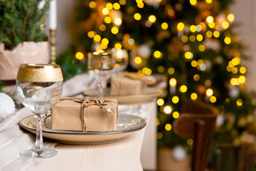 Christmas or New Year festive table setting. Christmas present in a plate on the table.