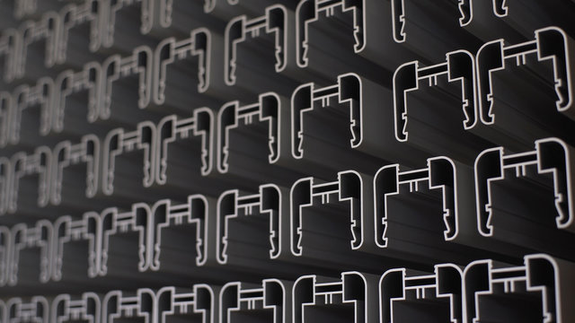 Complex lightweight extruded aluminium metal profiles, commonly used as material in construction and manufacturing. Resources stacked in an interesting, artistic, abstract pattern.