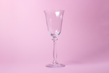 Glass goblet on a pink background. There is a place for writing or logo on the glass
