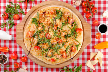 Pizza with seafood, mozzarella, mussels, octopus, squid, salmon, shrimp, cheeseand, fresh rucola and tomatoes sauce in italian restaurant background, top view. Mediterranean food.