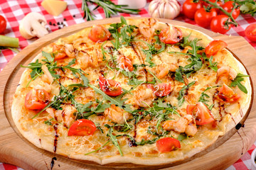 Pizza with seafood, mozzarella, mussels, octopus, squid, salmon, shrimp, cheeseand, fresh rucola and tomatoes sauce in italian restaurant background, top view. Mediterranean food.