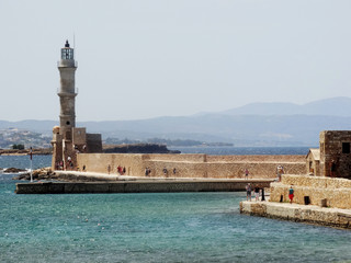 Fototapeta na wymiar Tourists visit the lighthouse in Chania central in Crete, Greece. The original Venetian lighthouse was built around the late 16th century to protect the harbour.