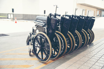 Obraz premium Rows of wheelchairs parking for disability patient services in medical hospital with copy space. Group of wheelchairs Row service at hospital