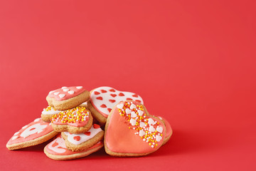 Decorated with icing and glazed heart shape cookies on the red background. Valentines Day food concept