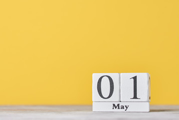 Wooden block calendar with date May 1 on the yellow background. Labor Day concept