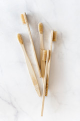 Composition with biodegradable bamboo toothbrushes on marble background. Sustainable, zero waste, plastic free, lifestyle concept. Eco-friendly oral hygiene accessories.Flat lay, top view.