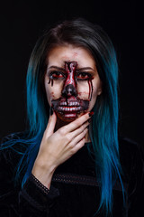Portrait of bloody horrible scary zombie woman in a halloween festive makeup