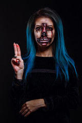 Portrait of bloody horrible scary zombie woman in a halloween festive makeup