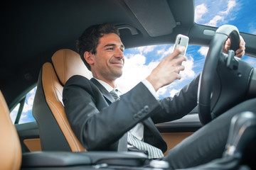 Man using his mobile phone while driving, dangerous behaviour concept