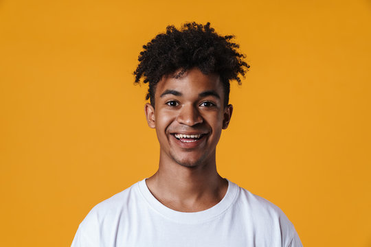 Image of happy african american guy smiling and looking at camera