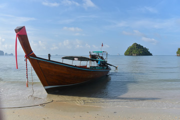 Fototapeta na wymiar A traditional Thai long tail boat moored on the beaches of the islands of Krabi and the Andaman Sea famous tourist destination in southern Thailand.