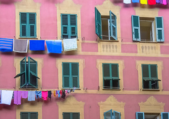 Façade typique de l'Italie avec linge étendu aux fenêtres. Fenêtres entre-ouvertes avec volts à persienne. 