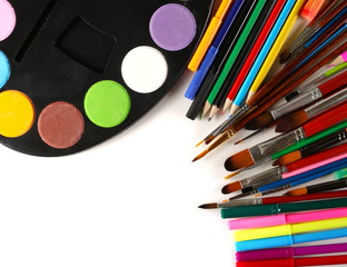 Naklejka premium Paint palette with watercolors, paintbrushes colorful pencils and felt markers pile, painting utensils isolated on white background