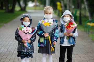 Schoolchildren, a boy and girls in medical masks.