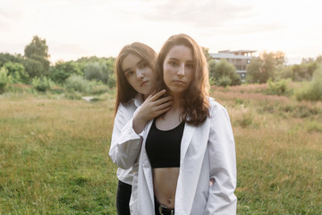 Two young caucasian girls posing in the grass. Moments Happiness Concept