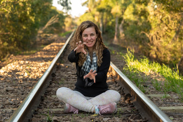 Young man wearing a Scarf and black blouse posing for photos on the abandoned railroad