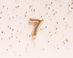 Seven year birthday. Number 7 flying foil balloon and confetti. Seven-year anniversary background. 3D rendering