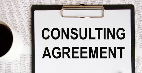 Inscription on a sheet of paper from the daily CONSULTING AGREEMENT, next to glasses, pencil.
