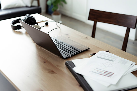 テーブルの上のノートパソコンと書類とインカム