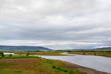 Fototapeta na wymiar Beautiful scene of a river under the cloudy sky in Iceland