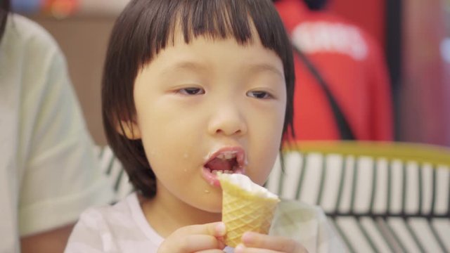 video Close up 3 year old Asian cute kid eat ice cream. Concept for dessert and family lifestyle.