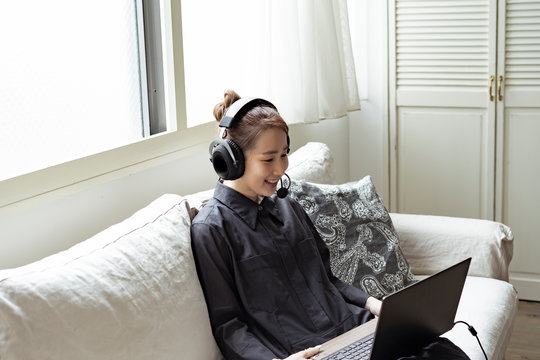 インカムをつけてノートパソコンを見る日本人女性