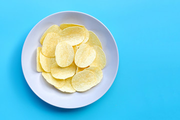 Potato chips on blue background.