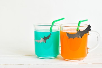 Festive homemade Halloween cocktail.
Cute Halloween drinks for a kids party on white wooden background. Concept holiday, Halloween.