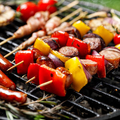 Grilled  meat and vegetable skewers on cast iron grill close up view