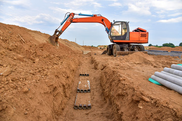 Excavator dig the trenches at a construction site. Trench for laying external sewer pipes. Sewage...