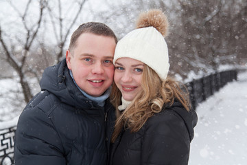 Fototapeta na wymiar Young couple hugging in winter park