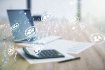 Double exposure of social network icons hologram and world map on blurry calculator with laptop background. Marketing and promotion concept