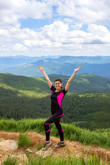 Happy young girl with raised hands on a background of beautiful mountains. Ukraine. Carpathians. Recreation.