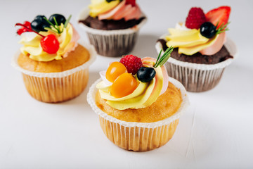 chocolate cupcakes with cream and fresh berries
