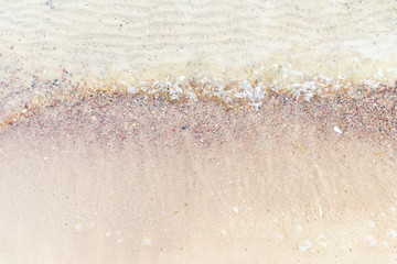 Top view Soft wave of the sea on the sandy beach with white clean foam.