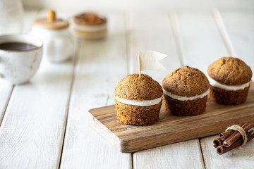 Carrot muffins with nuts and cream on a white plate. Vegan muffins. Traditional donkey pastries. Selective focus. Copy space.