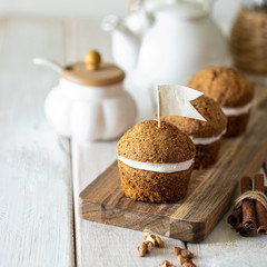 Carrot muffins with nuts and cream on a white plate. Vegan muffins. Traditional donkey pastries. Selective focus. Square