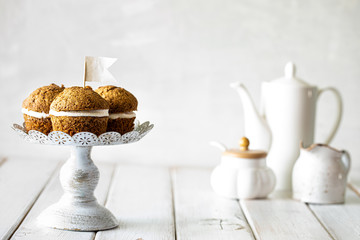 Carrot muffins with nuts and cream on a white plate. Vegan muffins. Traditional donkey pastries. Selective focus. Copy space.