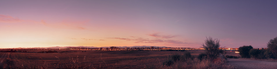  Sunset over the city lights panorama