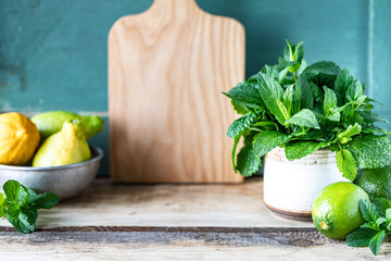 Fresh mint, lime and lemons on a wooden table. Mint drink or mojito recipe. Selective focus. Copy space.