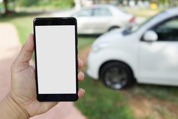 Man using smartphone while walking to his car at outdoor car park