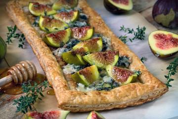 Puff pastry biscuit with figs, Camembert cheese and poured with honey.