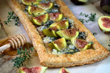Puff pastry biscuit with figs, Camembert cheese and poured with honey.