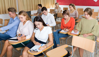 Small group of students attentively listening to lecture in classroom..