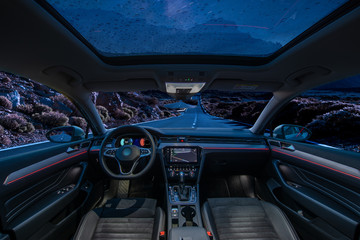  car is in autonomous driving mode with a panoramic glass roof while driving at night in the...